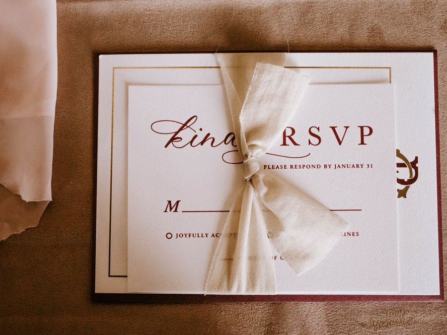 Invitation card tied with a ribbon resting on an envelope