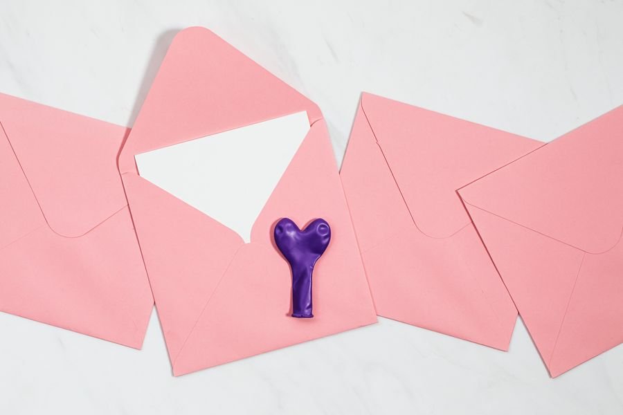 Pink envelopes with celebration invitation and balloon shapes